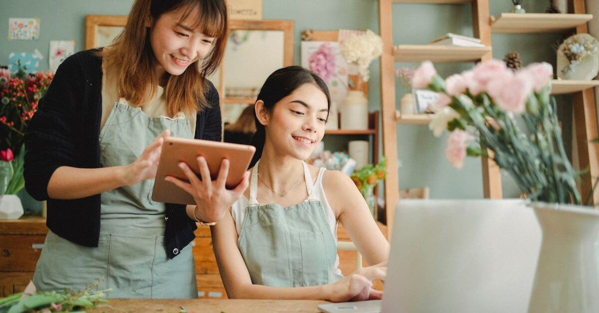 happy-women-working-on-gadgets-in-floral-store-247-self-storage-shop-spaces-for-storage-facilities