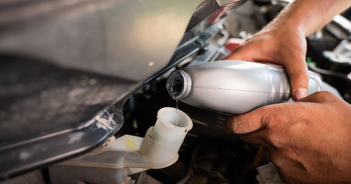 person adding fluids to car - 247 Self Storage winter car storage