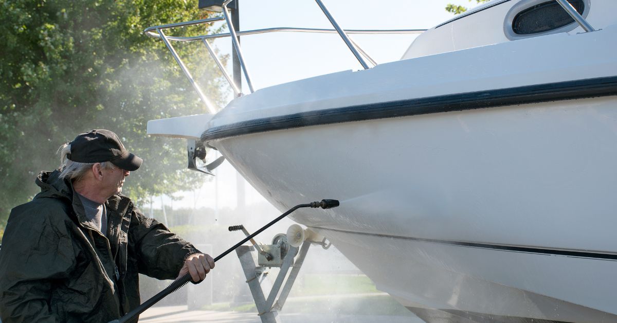 man cleaning his boat with a power washer - 247 Self Storage boat storage