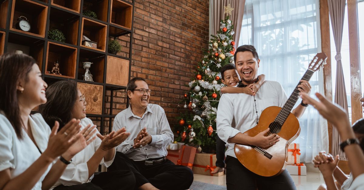 family playing music by holiday tree in their living room - 247 Self Storage self storage