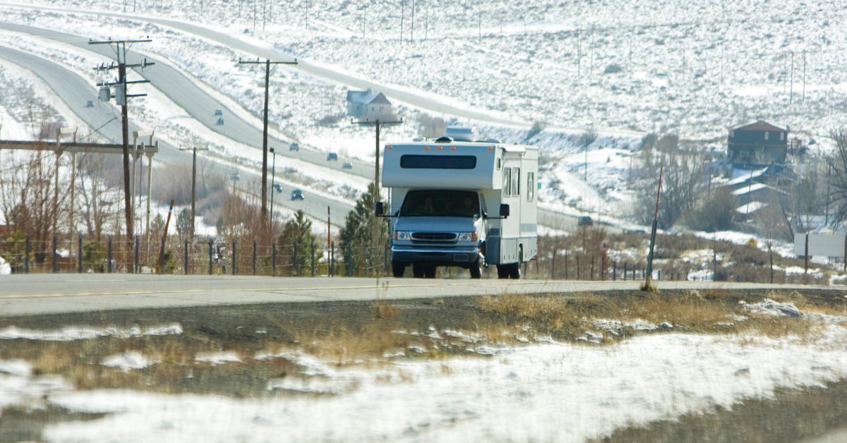 rv driving in a snow covered mountain range - 247 Self Storage RV Storage Solutions